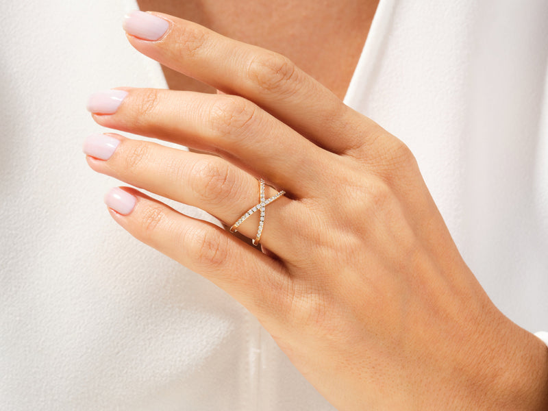 Diamond criss-cross ring on a woman's hand, fine jewelry