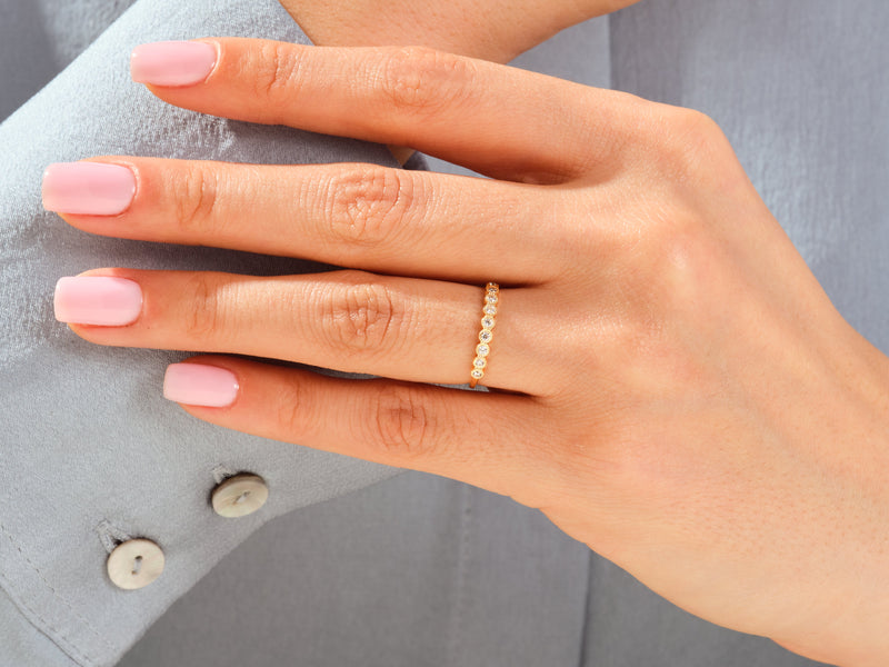 Gold diamond band ring on a woman's finger