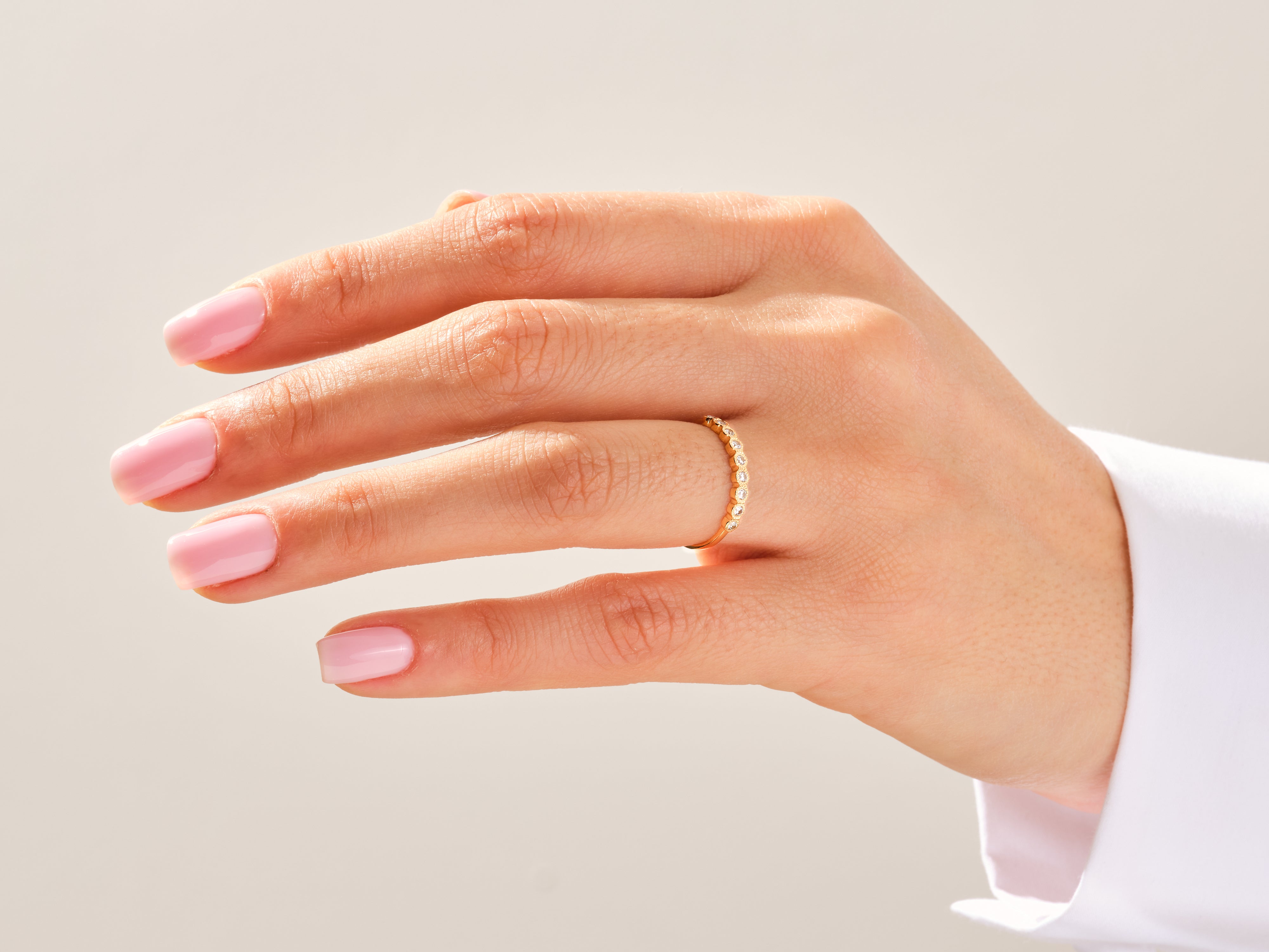 Gold diamond eternity band ring on a woman's finger