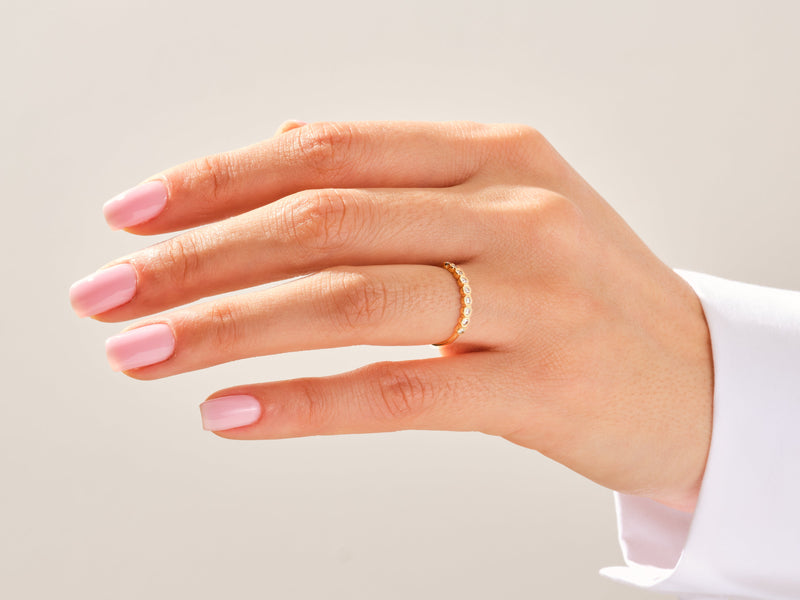 Gold diamond eternity band ring on a woman's finger