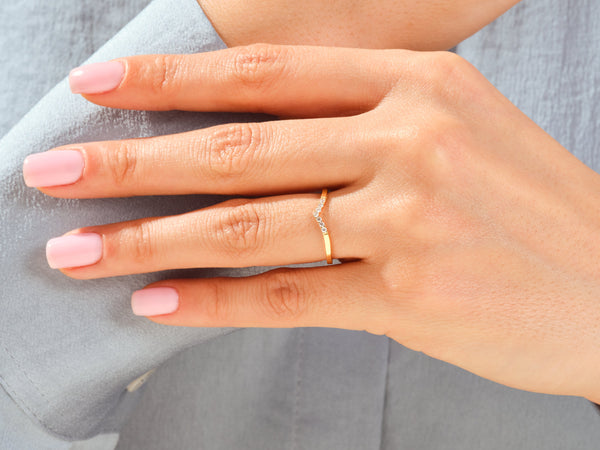 Gold chevron ring with diamonds on a woman's hand