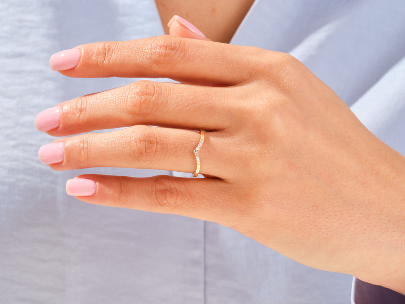Diamond curved band ring on a woman's finger