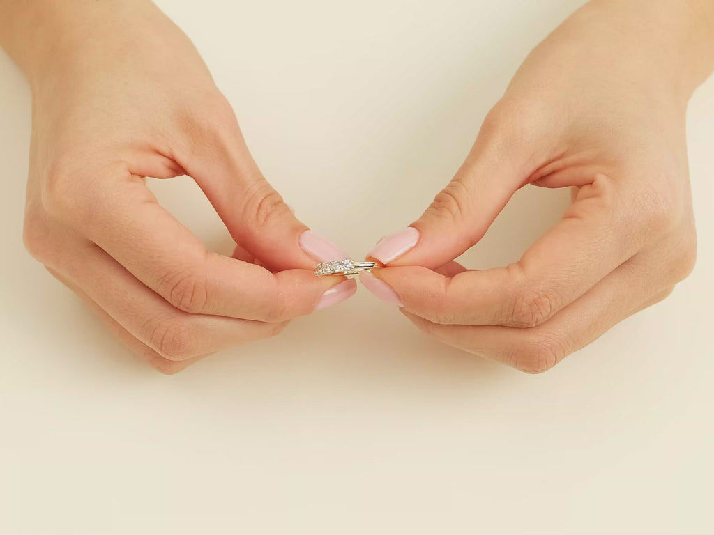 A video showcasing a hand wearing a yellow gold u-prong five stone moissanite anniversary band