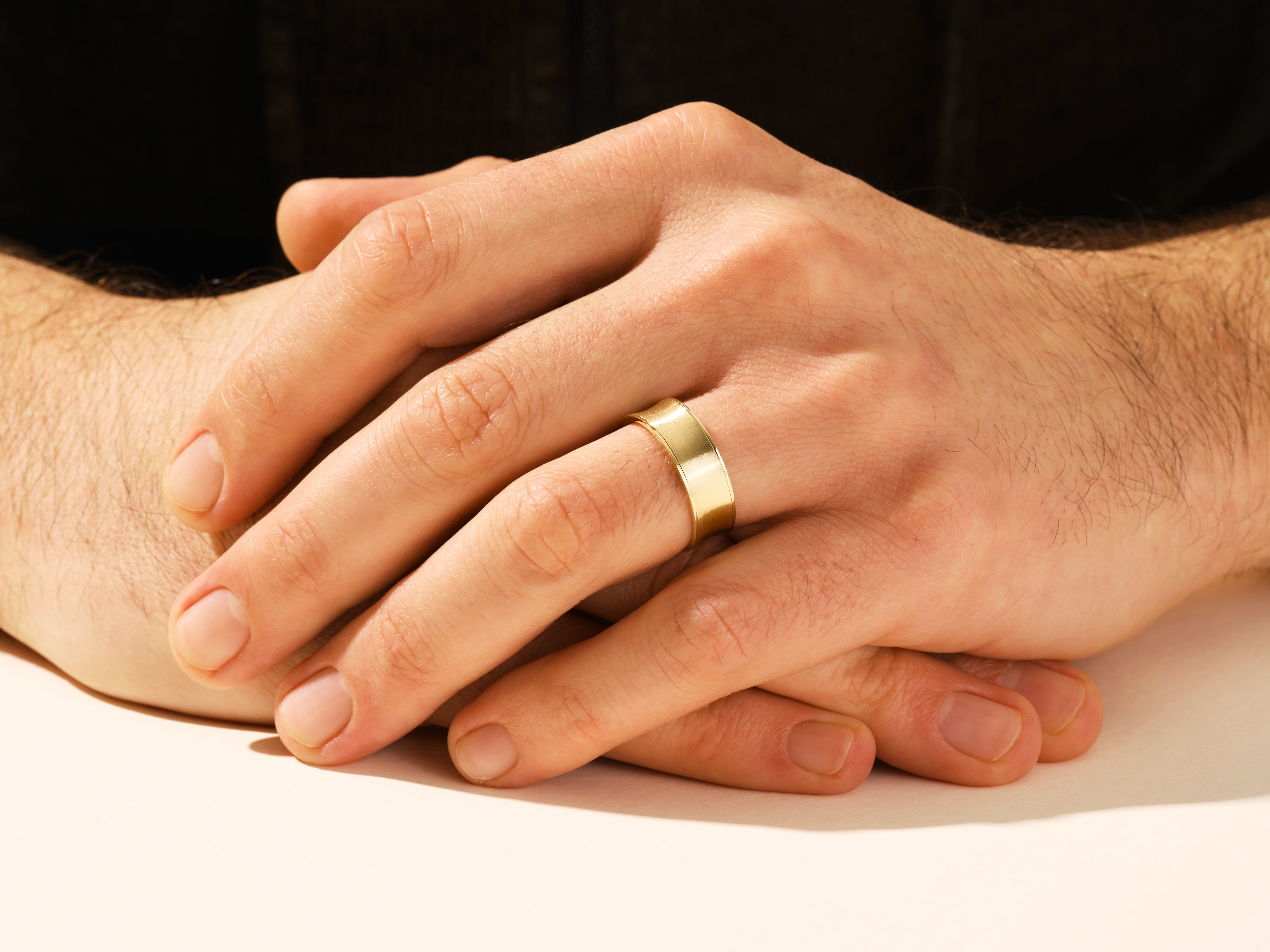 Men's gold wedding band on hand, jewelry photography