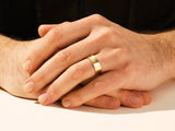 Men's gold wedding band on hand, jewelry photography