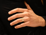 Gold ring with geometric pattern on man's finger