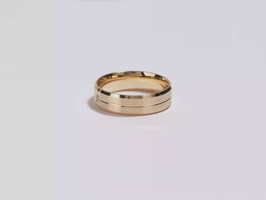 A video showing a yellow gold a yellow gold 6mm beveled edge, grooved and flush set men's diamond wedding band spinning on a white background.