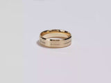 A video showing a yellow gold a yellow gold 6mm beveled edge, grooved and flush set men's diamond wedding band spinning on a white background.