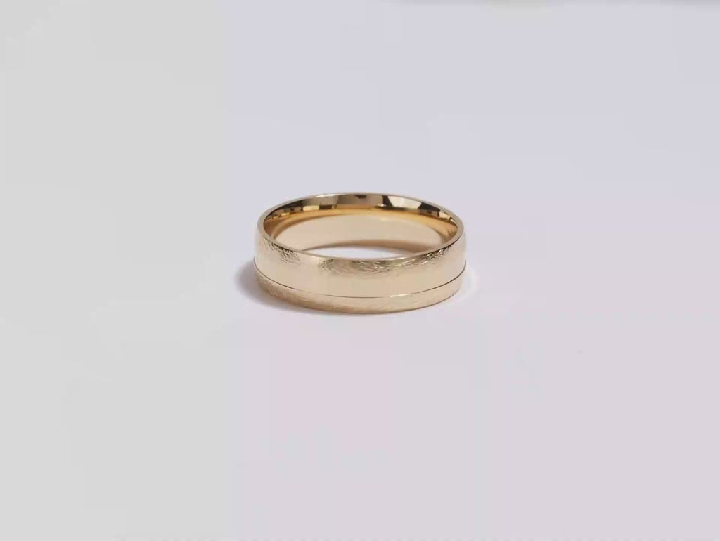 A video showing a yellow gold 6mm ice matte grooved men's wedding band spinning on a white background