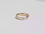 A video showing a yellow gold 4mm slit-bezel set eternity men's diamond wedding band spinning on a white background.