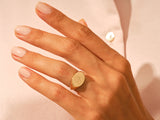 Gold heart signet ring on a woman's finger, fine jewelry