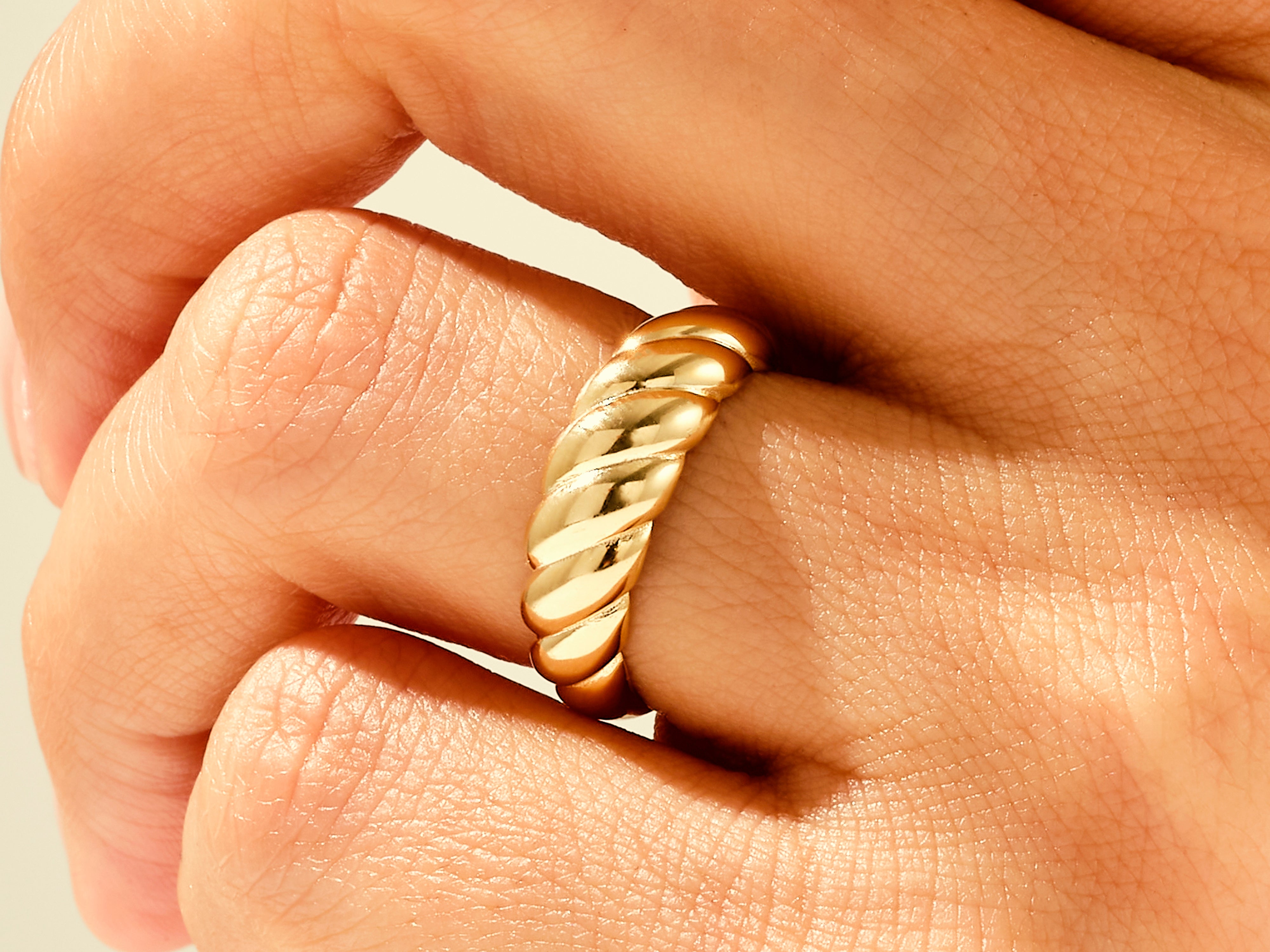 Gold twisted ring on finger, fine jewelry for women