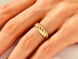 Gold twisted ring on a finger, fine jewelry for women