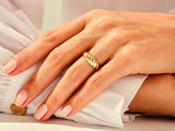 Gold twisted ring on a hand, elegant jewelry for women