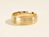 Gold wedding band with brushed finish and polished groove detail