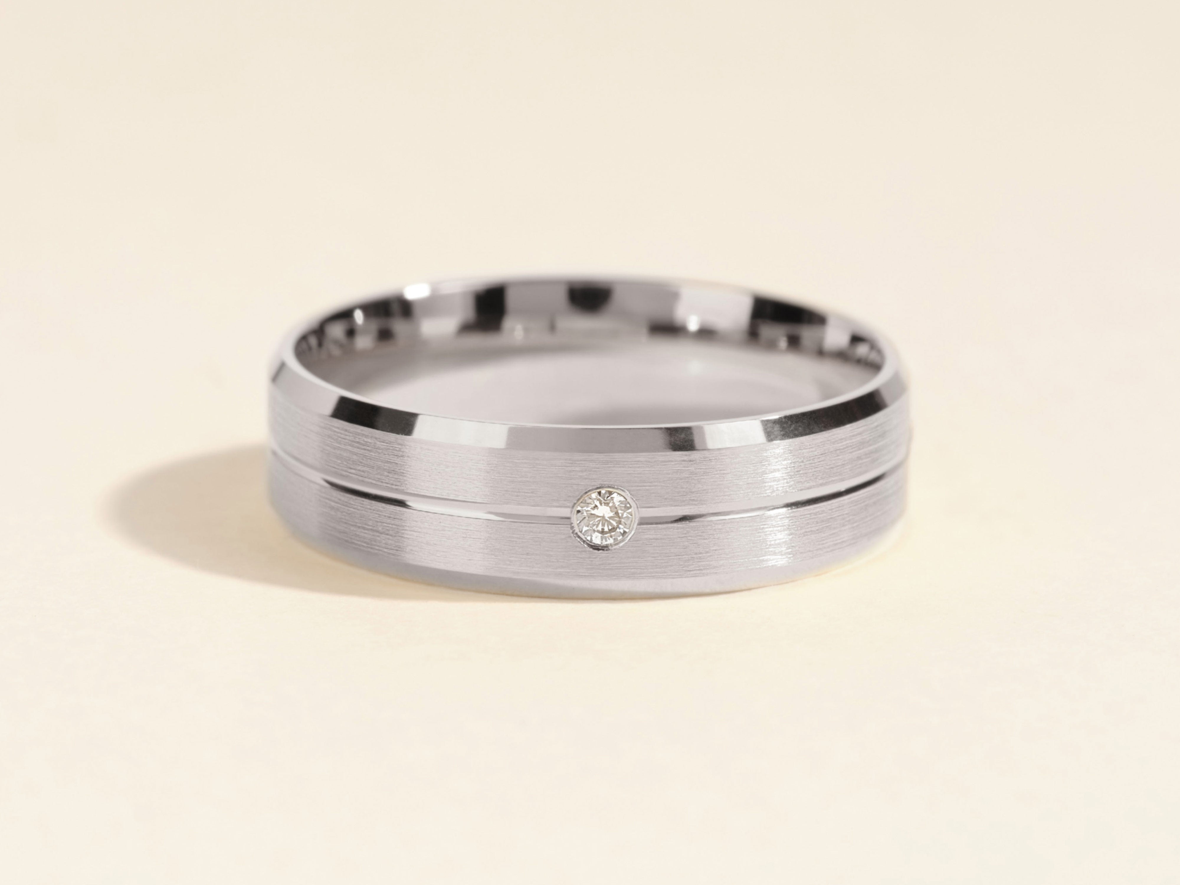 Men's brushed silver ring with a single diamond accent