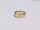 A video showing a yellow gold 6mm grooved block men's Gold wedding band spinning on a white background.