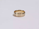 A video showing a yellow gold 7mm matte beveled edge men's wedding band spinning on a white background.